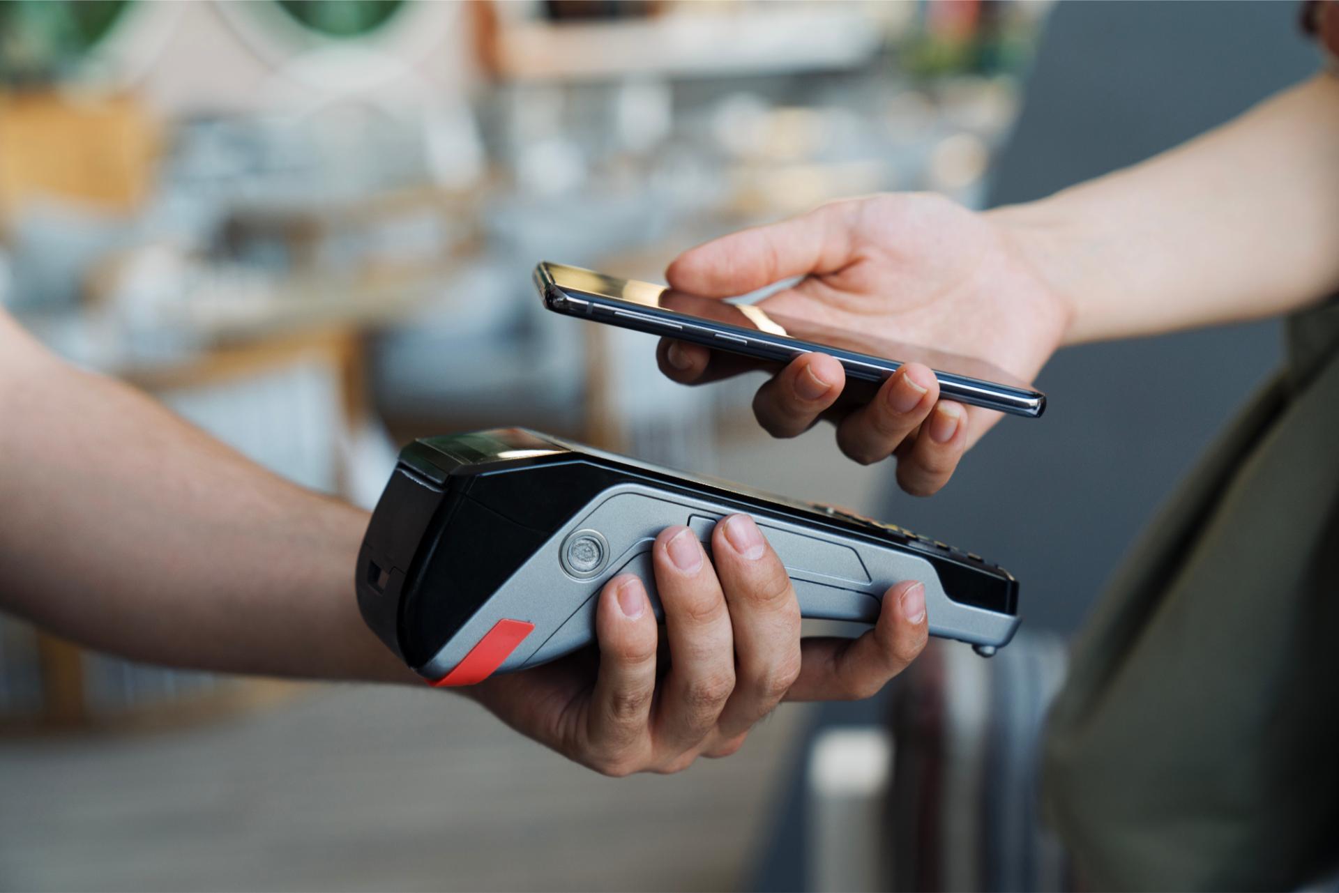 A person is paying for something with a credit card and a phone