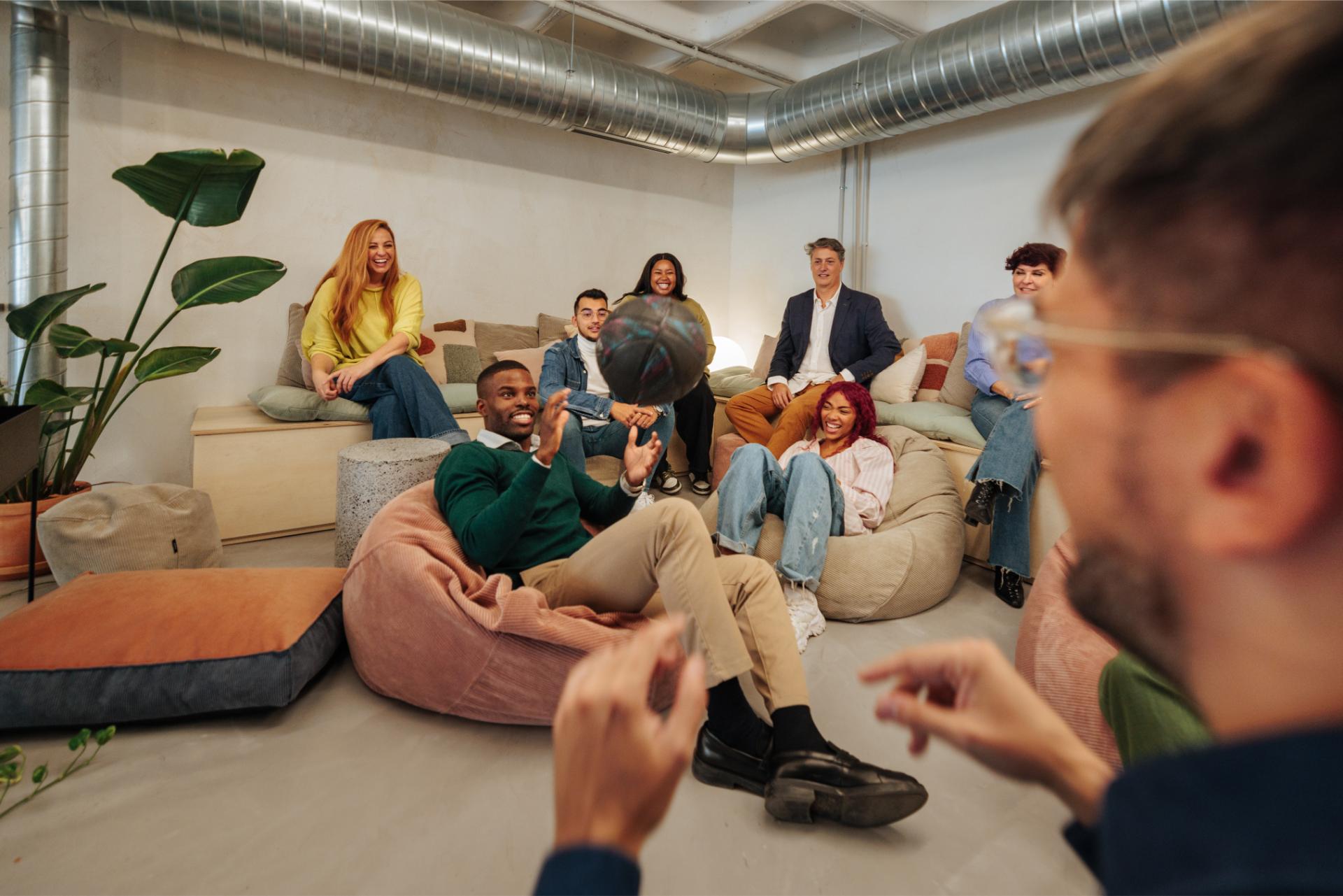 Diverse business team playing with basketball during break time in modern office