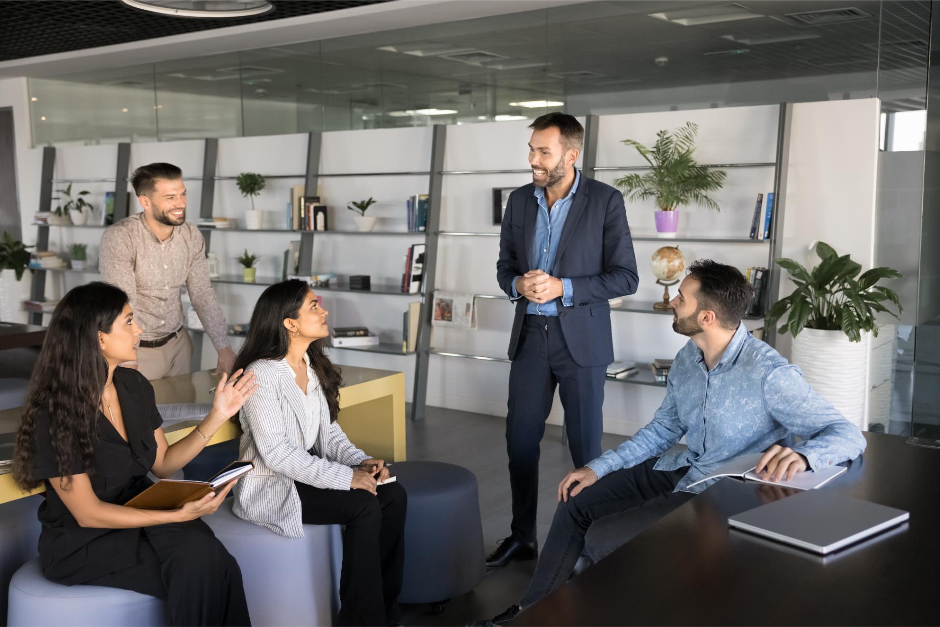 Group of five diverse professionals engaging in team meeting brainstorming session