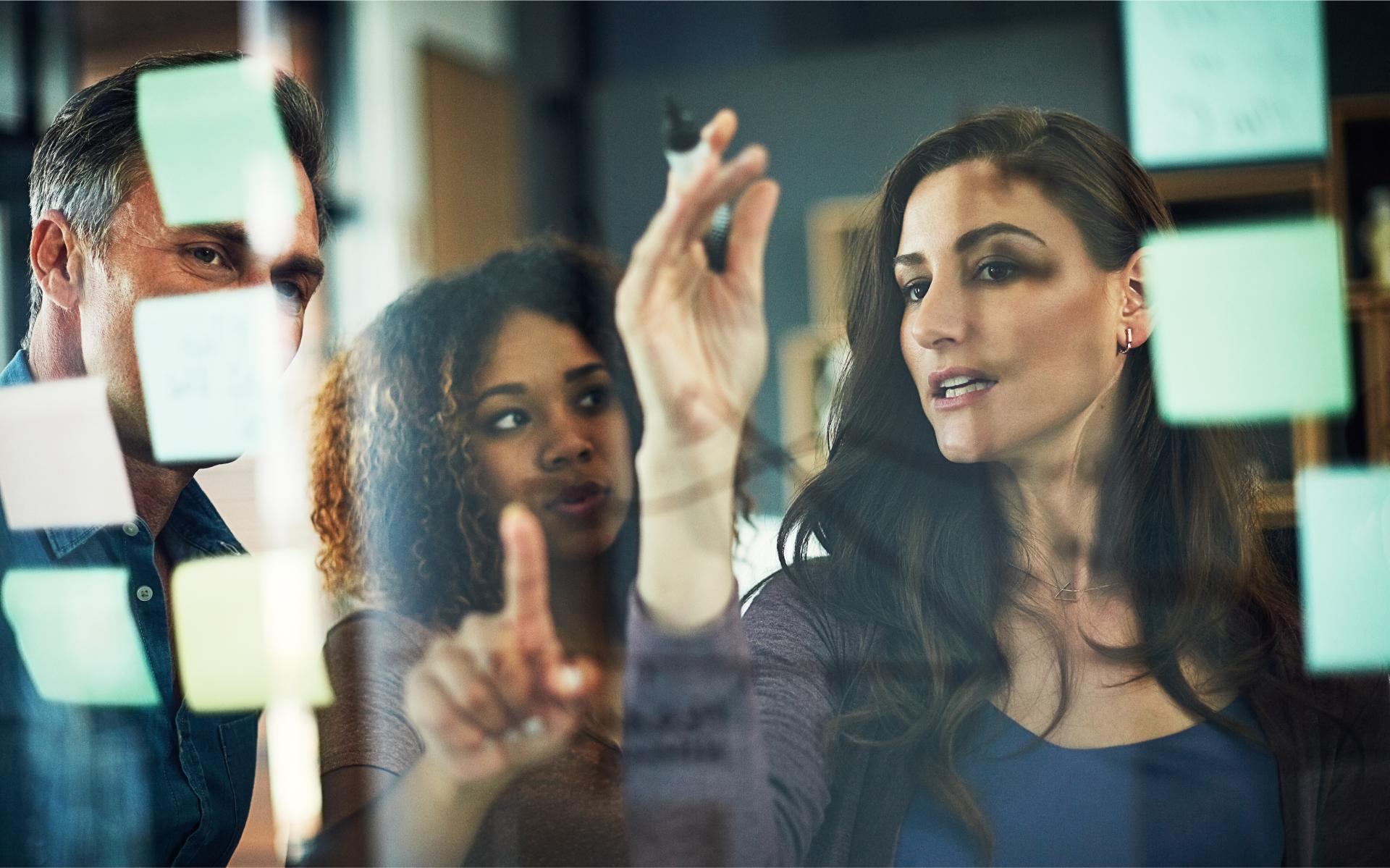 Business people meeting or pointing with glass board for project planning brainstorming or schedule at office