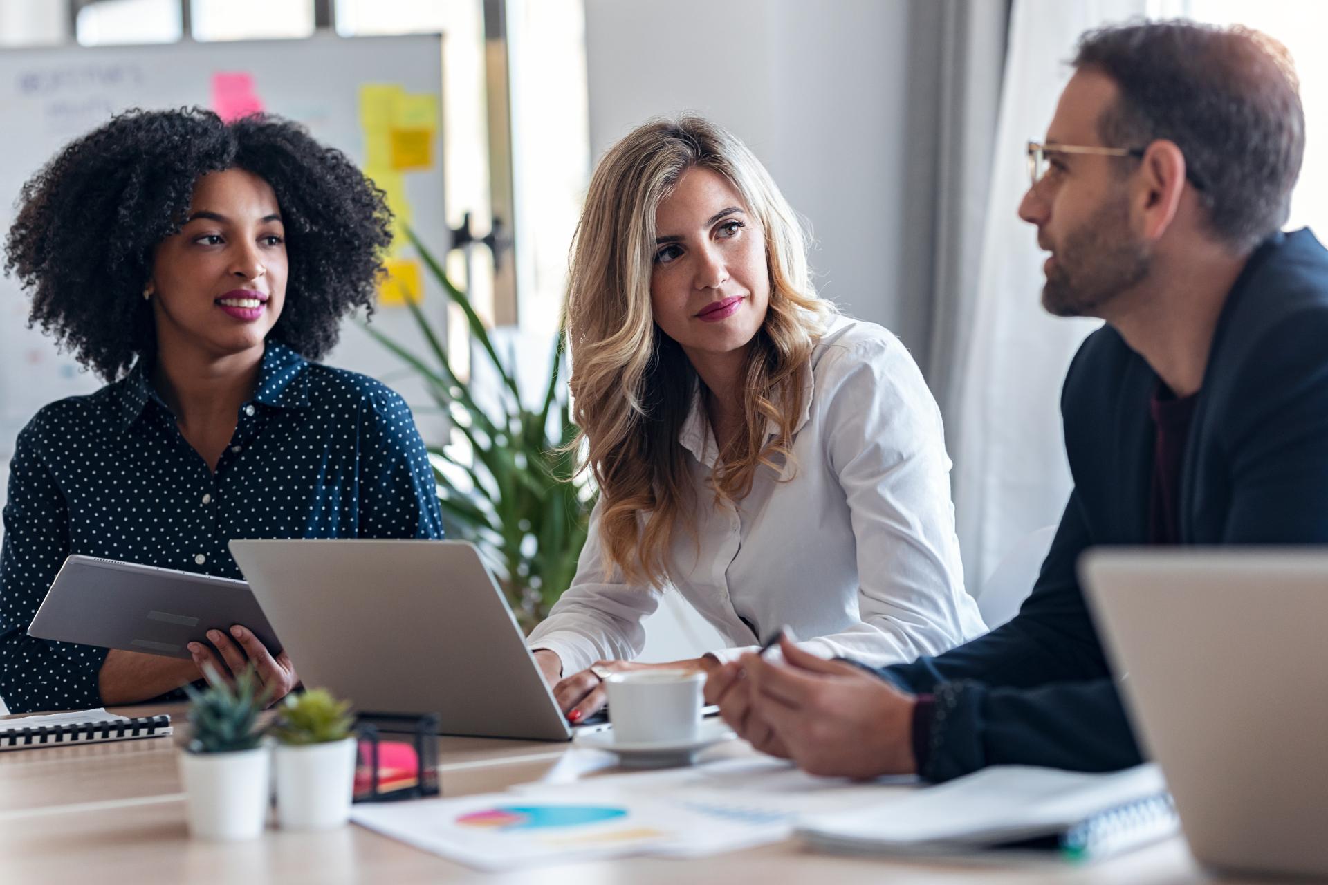 Casual multiage business people working with laptops while talking of they new project together in modern startup