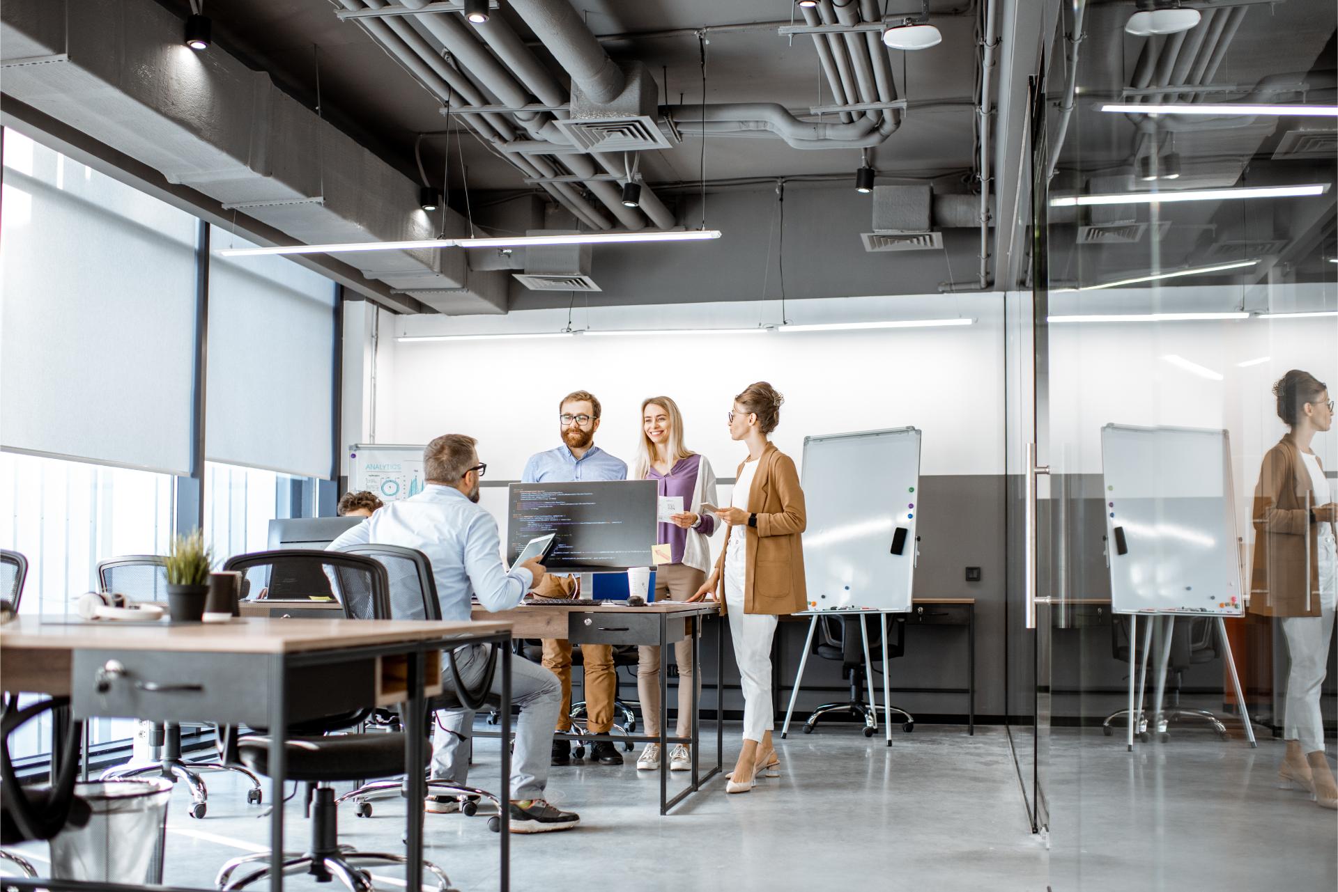 Interior view on the modern office room with diverse people working on the computers indoors